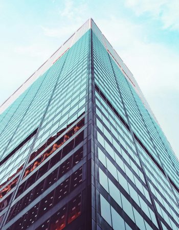 Low angle view of a modern skyscraper in New York City showcasing architectural design against a clear sky.